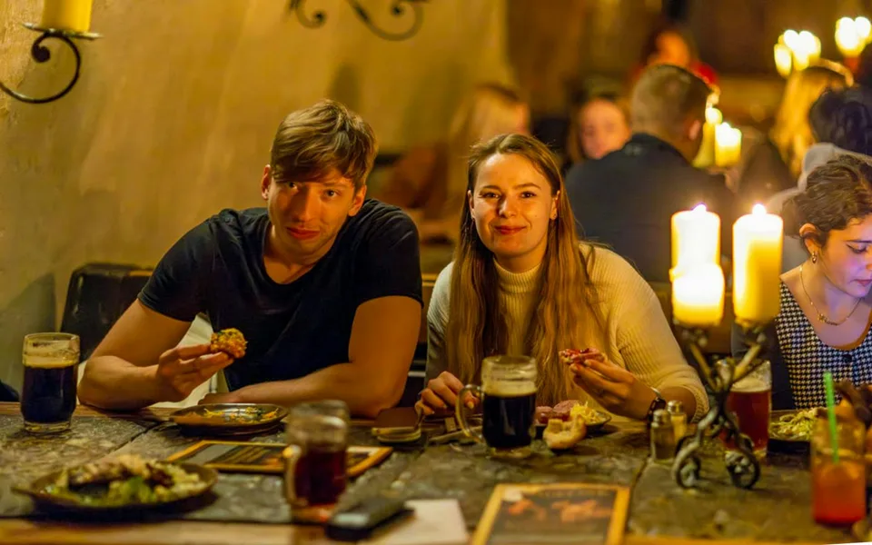 Guests seated at a candlelit medieval dinner