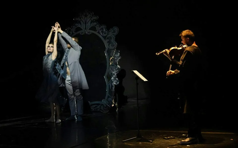 Violinista y artista escénico bajo la iluminación teatral