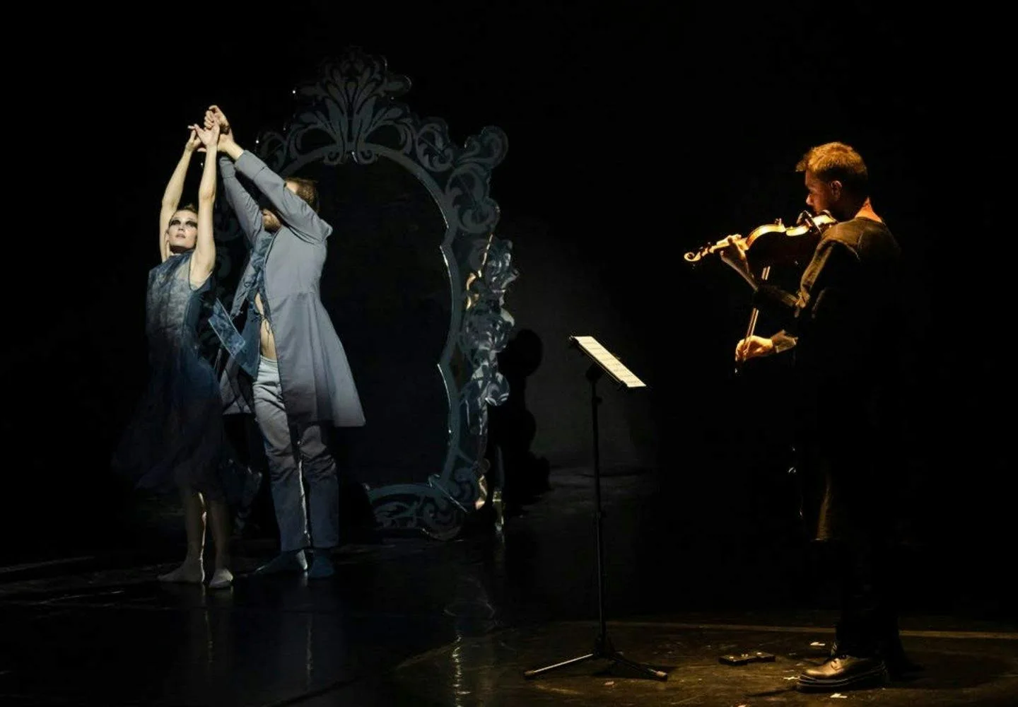 Violinista y artista escénico bajo la iluminación teatral