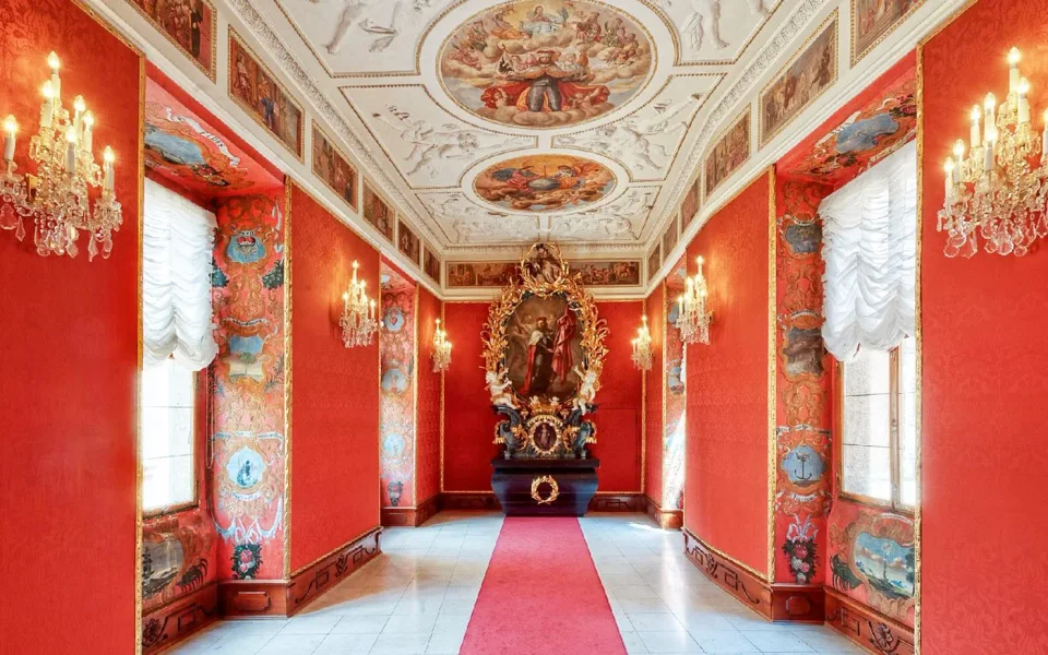Painted ceiling and red walls inside Lobkowicz Palace