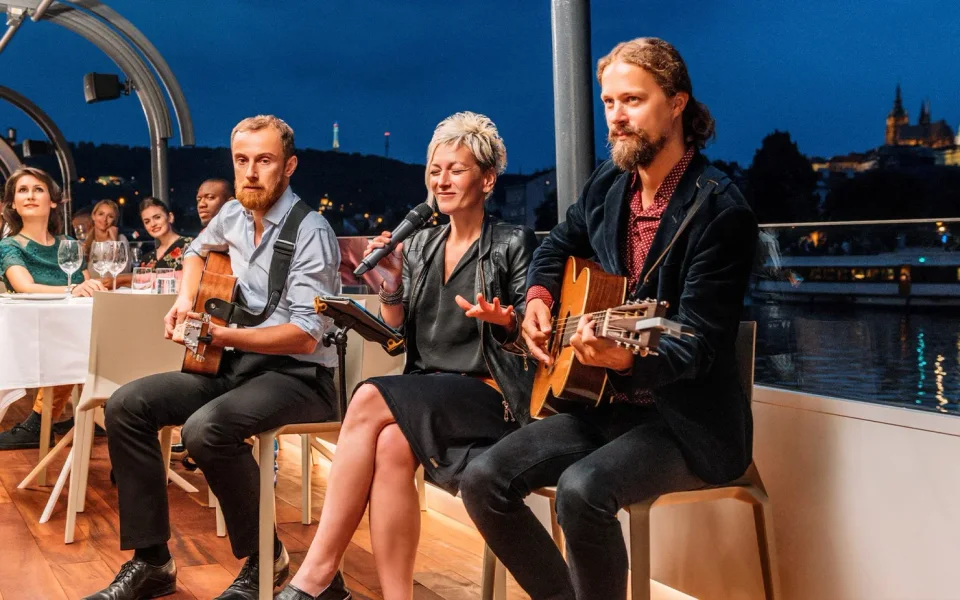 Musicians performing beside diners on a Prague evening cruise