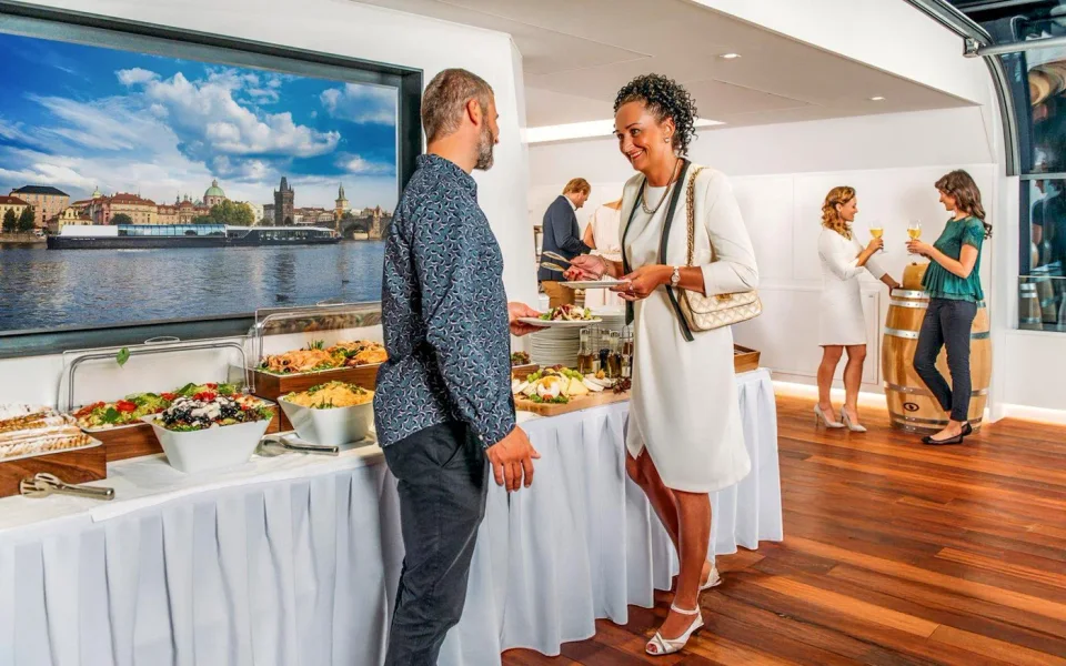 Passengers beside the buffet aboard a Prague dinner boat