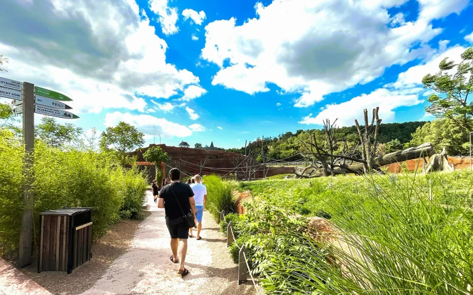 Visitors walking along a garden path at Prague Zoo