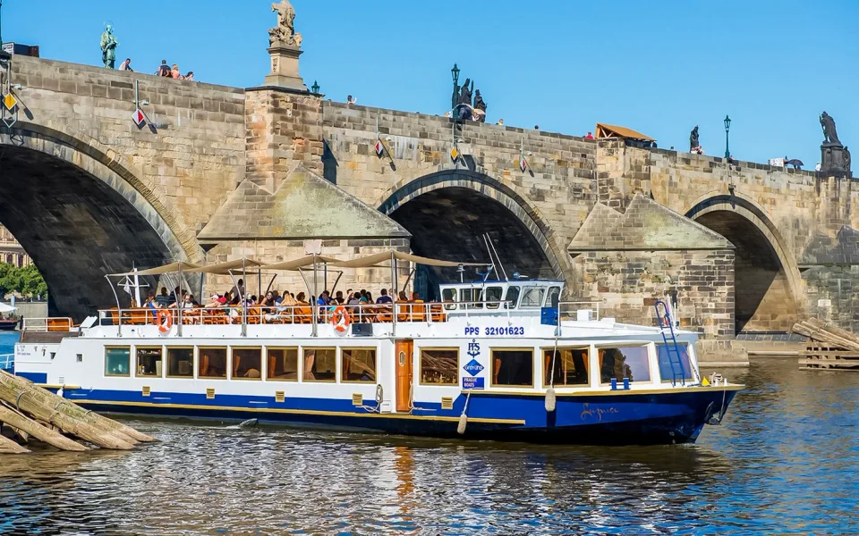 Passenger boat beside the stone arches of Charles Bridge